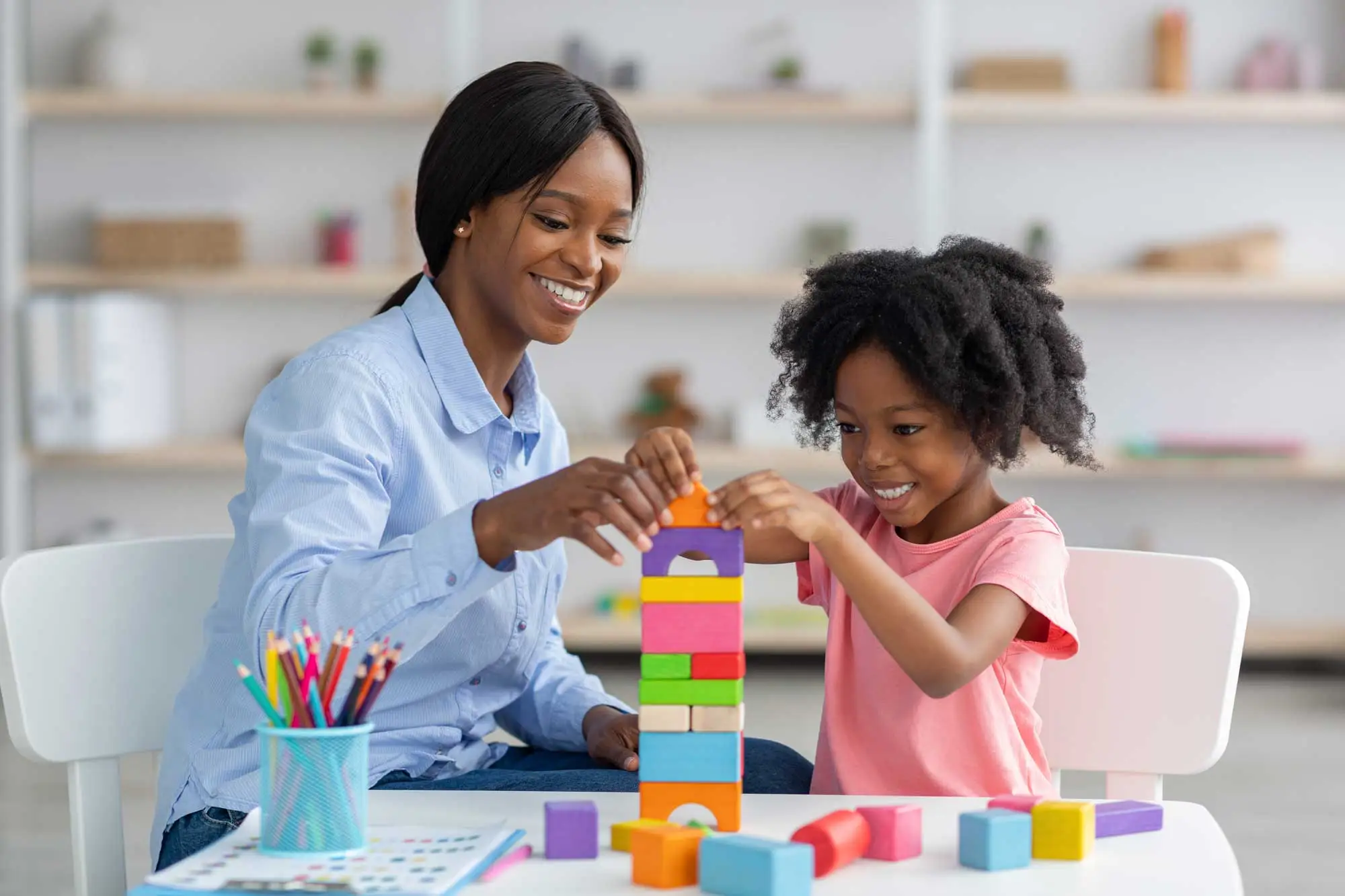 Young child smiling while engaged in an early learning activity at a child care center